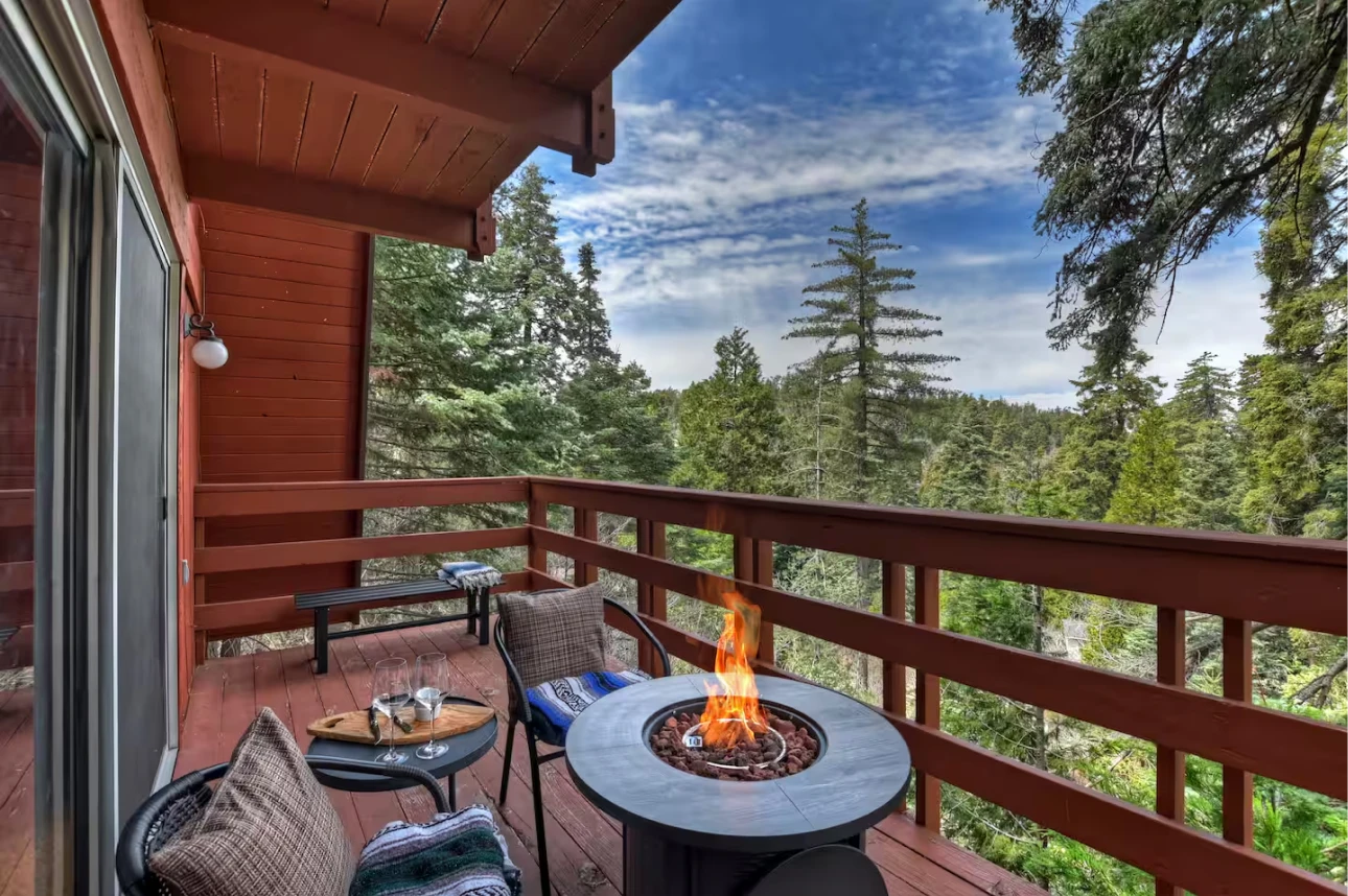 Skyforest Getaway deck with a fire table and forest view